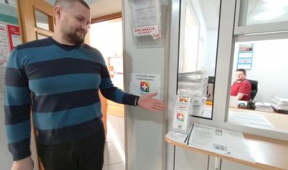Pracownik Urzędu Miejskiego w Połczynie-Zdroju Mateusz Owczarek prezentuje nowe naklejki