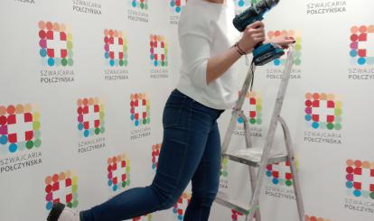 Zastępca Burmistrza Emilia Mazur (z wiertarką) w zmaganiach z nową ścianką promocyjną w UM w Połczynie-Zdroju