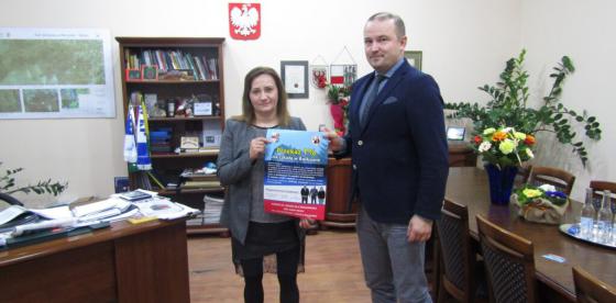Burmistrz Sebastian Witek przekazuje materiały promocyjne Katarzynie Włodarskiej