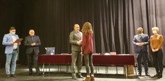 Burmistrz Sebastian Witek wręcza drobne upominki i podziękowania dla solisty ze Studia "Art Voice" z CK - Antka Ostrowskiego.