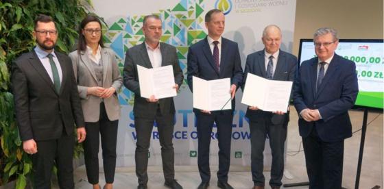 Skarbnik Gminy Rafał Fischer - trzeci od lewej - prezentuje umowę