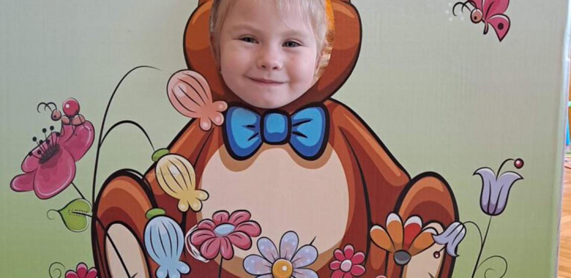 Przedszkolak w fotobudce z wizerunkiem pluszowego misia