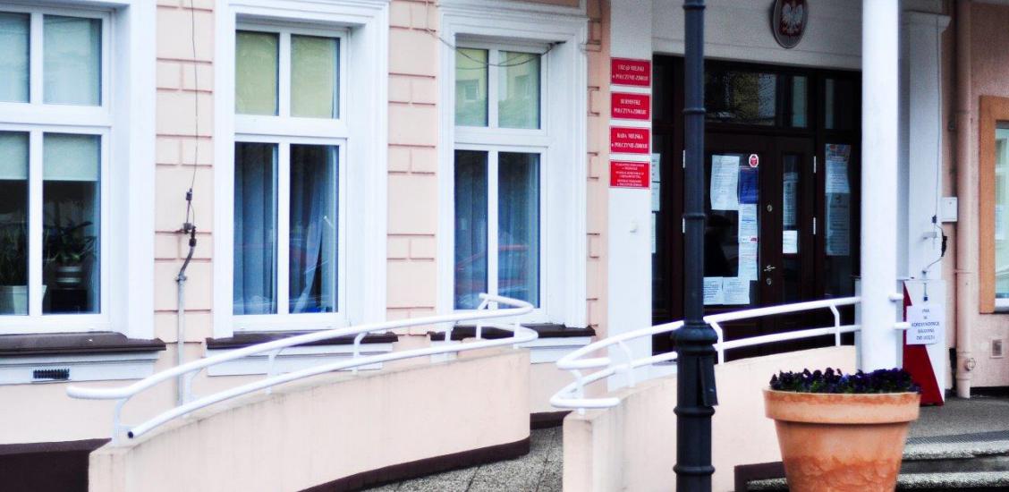 Wejście do Urzędu Miejskiego w Połczynie-Zdroju. Przed budynkiem stoi urna.