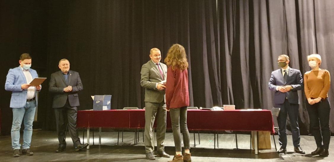 Burmistrz Sebastian Witek wręcza drobne upominki i podziękowania dla solisty ze Studia "Art Voice" z CK - Antka Ostrowskiego.