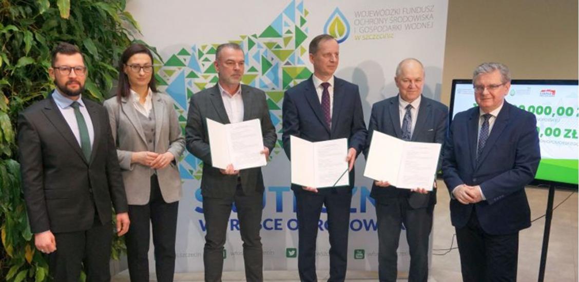 Skarbnik Gminy Rafał Fischer - trzeci od lewej - prezentuje umowę